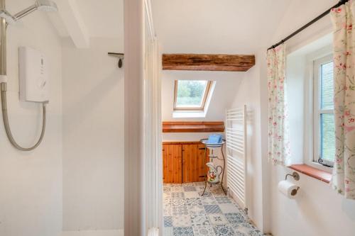 a bathroom with a shower and a window at Dyes Cottage in Hindolveston
