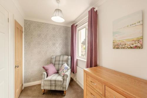 a living room with a chair and a window at Lionels Den in Wooler