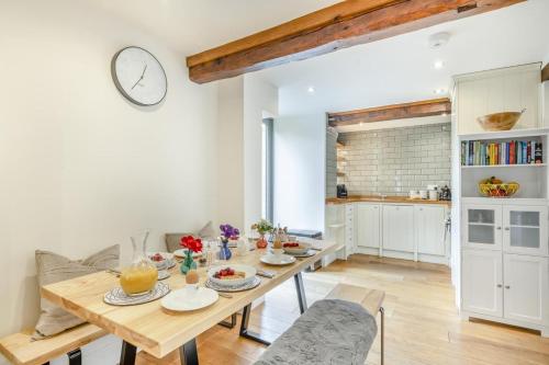 a dining room with a table and a kitchen at Swallows Barn in Little Snoring
