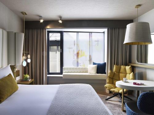 a bedroom with a bed and a living room at Sofitel Munich Bayerpost in Munich