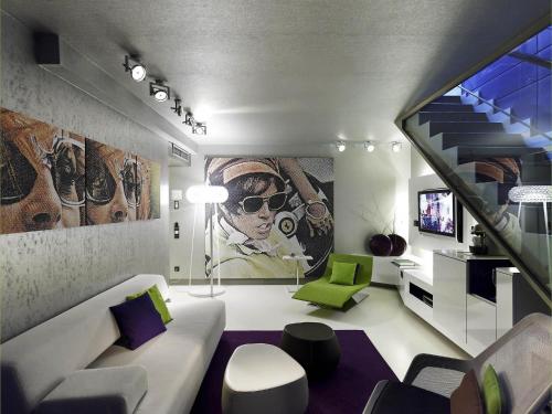 a living room with a white couch and green chairs at Sofitel Munich Bayerpost in Munich