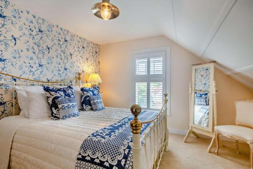 a bedroom with a bed with blue and white wallpaper at Fairholme in West Runton