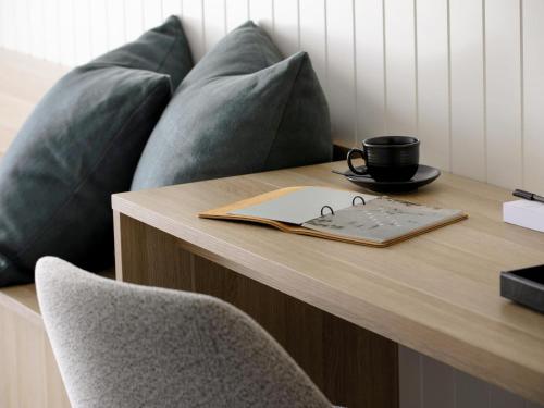a table with a cup of coffee on top of it at Manly Pacific Sydney MGallery Collection in Sydney
