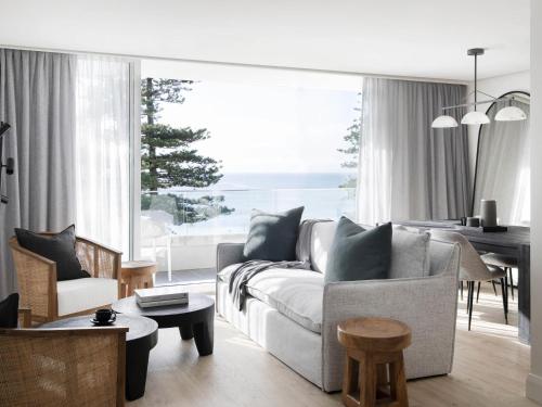 a living room with a couch and a table at Manly Pacific Sydney MGallery Collection in Sydney