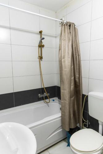 a bathroom with a toilet and a bath tub at Infinit Apartment in Prishtinë