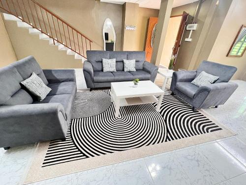 a living room with two couches and a table at D'Aya Sofea Homestay Padang Besar in Padang Besar