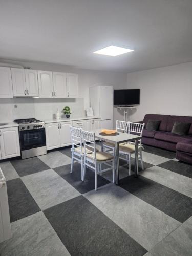 a kitchen with a table and chairs and a couch at Sunny Hill Apartments in Sînpetru
