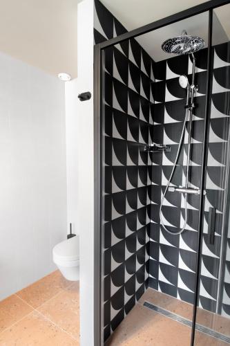 a bathroom with a black and white checkered wall at Hotel Zeedijk City Centre in Amsterdam