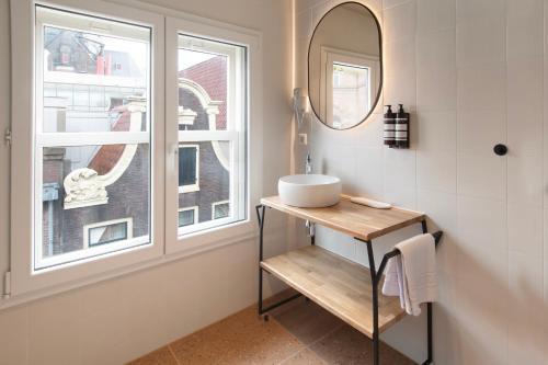 a bathroom with a sink and a window at Hotel Zeedijk City Centre in Amsterdam