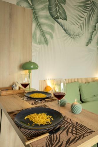 a table with two glasses of wine and a plate of food at Jungle Studio - Déco tropicale et confort moderne in Montoir-de-Bretagne