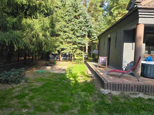 a yard with a deck with two chairs on it at Domek nad rzeką in Joniec