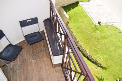 a balcony with two chairs and a bird on the grass at LUX Milmari L Apartments in Kopaonik