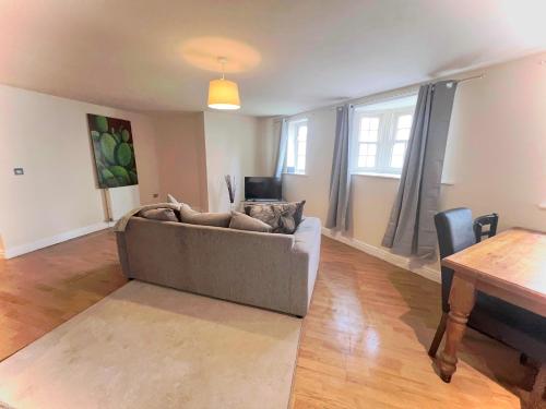a living room with a couch and a table at 2 bed Town Apartment in Shifnal