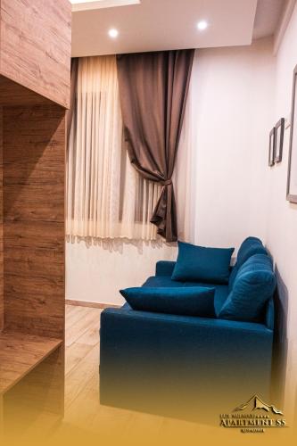 a blue couch in a room with a window at LUX Milmari L Apartments in Kopaonik