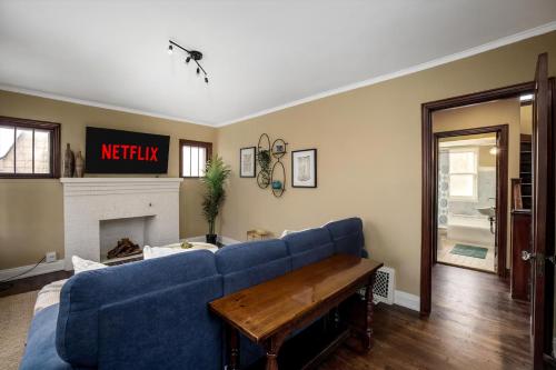 a living room with a blue couch and a fireplace at 10 Mins To The Big House and Sleeps Up To 10 Guests in Ann Arbor
