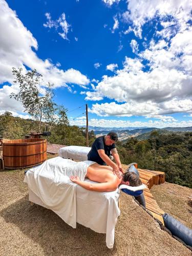 a man making a woman on a bed on top at Wagon Cella faroeste com Spa em Campos in Campos do Jordão