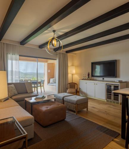 a living room with a couch and a tv at Viceroy at Ombria Algarve in Loulé