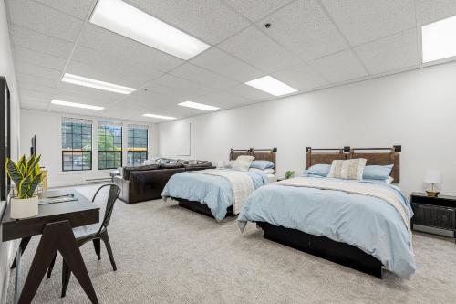 a bedroom with two beds and a table and a couch at The Loft- Steps from the Lake & Dining- This newly renovated 2 bedroom loft in the heart of McCall in McCall