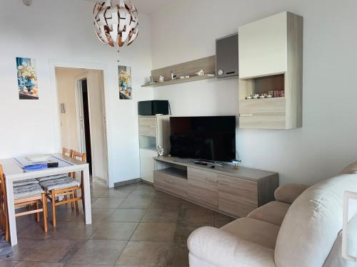 Una sala de estar con un sofá y una mesa con televisión. en Dream of the sea, en Vasto