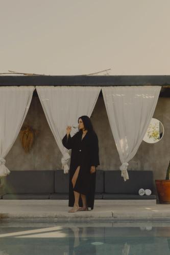 a woman is standing next to a pool at Casa Michaus Valle de Guadalupe in Valle de Guadalupe