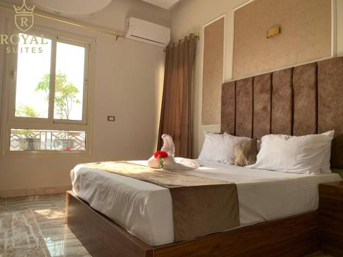ein Schlafzimmer mit einem Bett, auf dem ein Stofftier liegt in der Unterkunft Downtown Royal Suites in Kairo