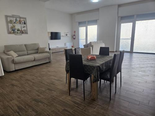 a living room with a table and chairs and a couch at Elysium Affittacamere in Mazara del Vallo