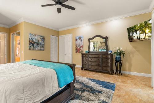 a bedroom with a bed and a dresser and a mirror at Paradise in Time in Port Saint Lucie