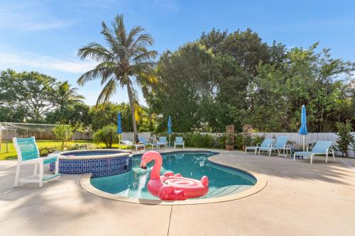 a swimming pool with a pink flamingo in it at Paradise in Time in Port Saint Lucie