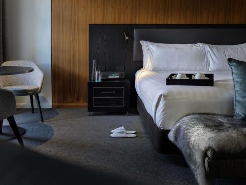 a hotel room with a bed and a chair at Sofitel Queenstown Hotel & Spa in Queenstown