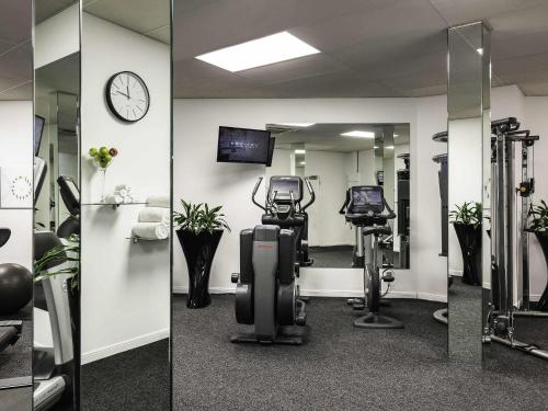 a gym with exercise equipment and a mirror at Sofitel Queenstown Hotel & Spa in Queenstown