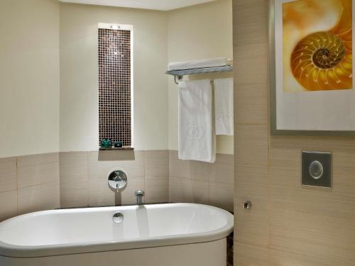 a bathroom with a bath tub and a window at Sofitel Al Khobar The Corniche in Al Khobar