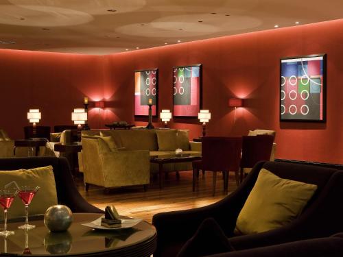 a restaurant with chairs and tables and red walls at Sofitel Al Khobar The Corniche in Al Khobar