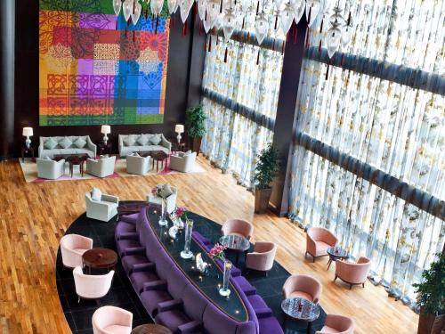 a room with purple couches and a large window at Sofitel Al Khobar The Corniche in Al Khobar
