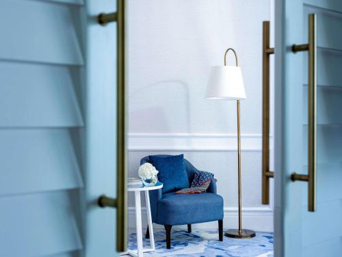 a blue room with a blue chair and a mirror at Sofitel Dubai Jumeirah Beach in Dubai