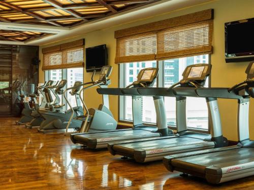 a gym with rows of exercise bikes in a room at Sofitel Dubai Jumeirah Beach in Dubai