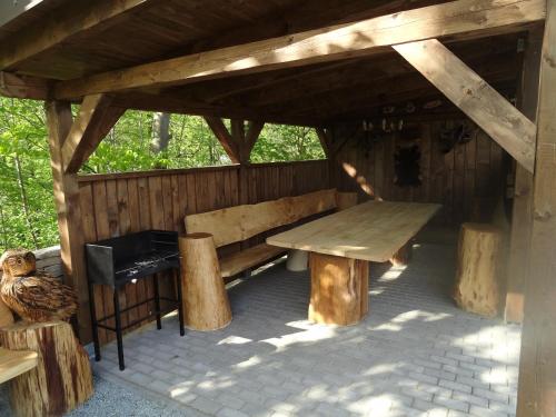a wooden pavilion with a bench and a table at Apartmány Hájenka in Vápenka