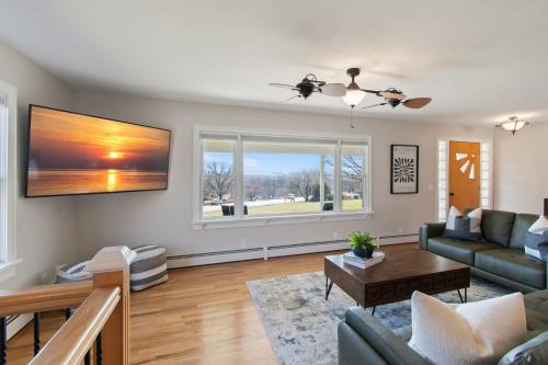 a living room with a couch and a table at High-End Finger Lakes Escape - Expansive Game Room, Cozy Firepit, & Scenic Views in Penn Yan