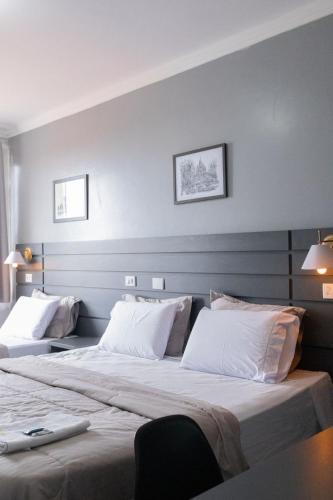 a bedroom with two beds with white pillows at Euro Hotel in Ubiratã