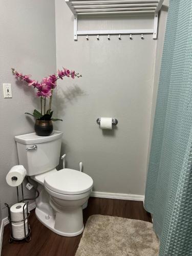 a bathroom with a toilet with a vase of flowers at Unique Waterfront Cottage 34 Mi To Mt Rainier in Eatonville