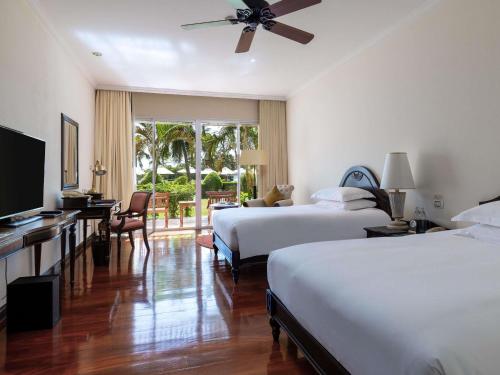 a hotel room with two beds and a flat screen tv at Sofitel Krabi Phokeethra Golf and Spa Resort in Klong Muang Beach