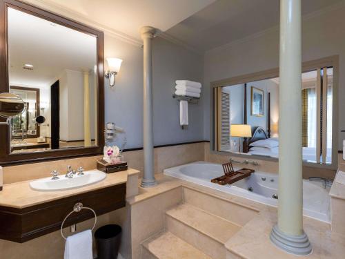 a bathroom with a tub and a sink and a bed at Sofitel Krabi Phokeethra Golf and Spa Resort in Klong Muang Beach