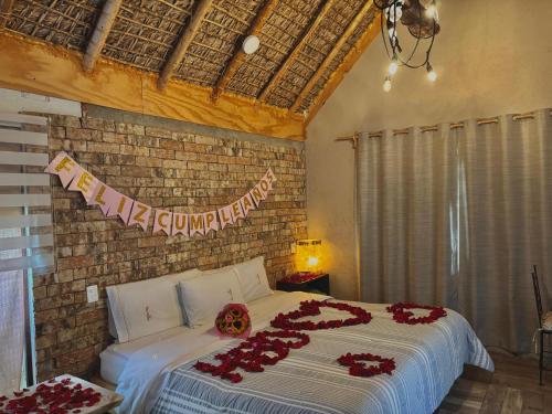 a bedroom with a bed with red flowers on it at Hotel Villas Mariposas in Atlixco