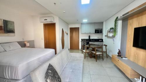 a bedroom with a bed and a kitchen with a table at Monte Carmel in Ribeirão Preto