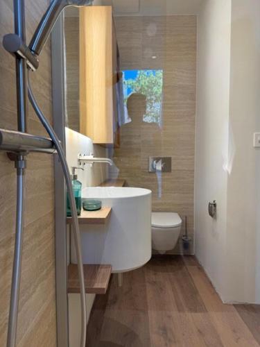 a bathroom with a white sink and a toilet at V&V Sky in Neuchâtel