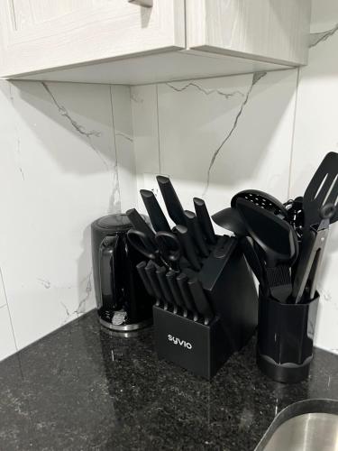 a bunch of kitchen utensils in a container on a counter at One bedroom private entrance suite in Edmonton