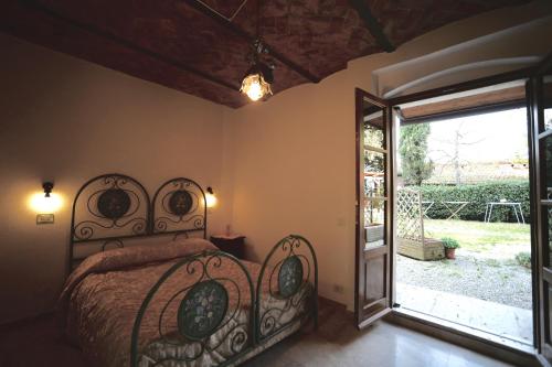 a bedroom with a bed and a door to a yard at La Spiga D'Oro in Foiano della Chiana