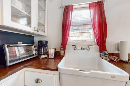 una cocina con fregadero y microondas en Hidden Villa Cottage #1 - The Nautical Cottage, en Cannon Beach