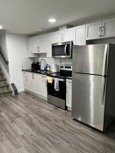 a kitchen with stainless steel appliances and white cabinets at One bedroom private entrance suite in Edmonton