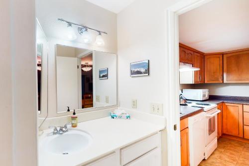 een keuken met een wastafel en een spiegel bij Red Pine Condos Unit #A7 in Park West Ski Area Heliport