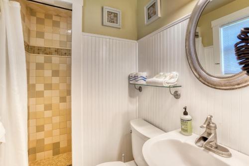 ein Badezimmer mit Waschbecken, Toilette und Spiegel in der Unterkunft Hidden Villa Cottage #5 - The Sunflower Cottage in Cannon Beach